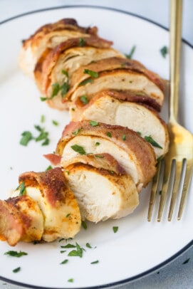 Close-up of slices of bacon wrapped chicken breast on a plate