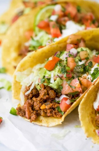 ground beef taco topped with lettuce, avocado, pico de gallo and sour cream