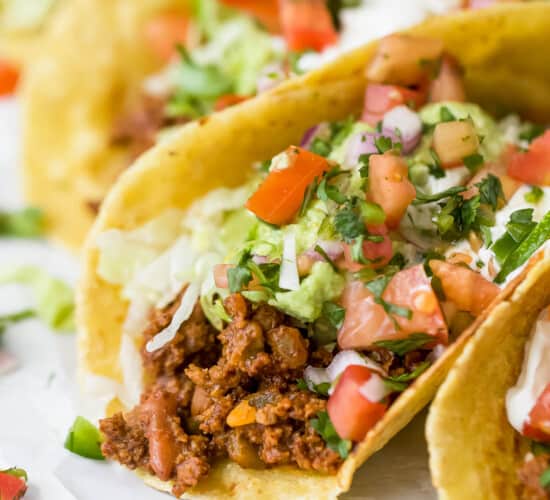 ground beef taco topped with lettuce, avocado, pico de gallo and sour cream