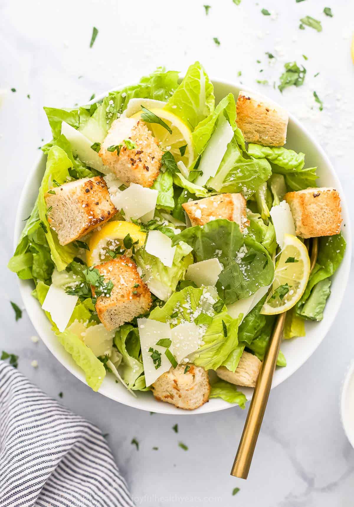 A bowl filled with caesar salad shown from above