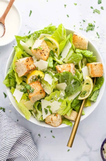 Homemade caesar salad in a bowl on a marble countertop