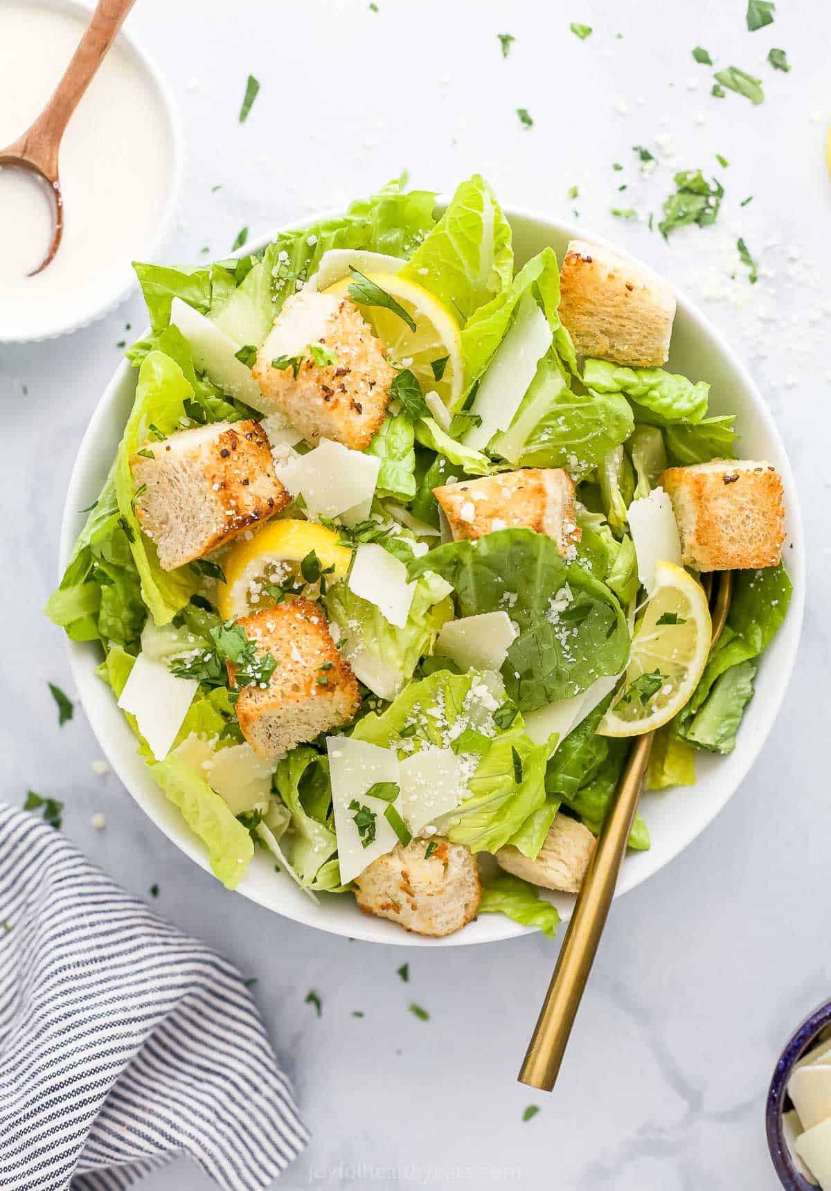 Homemade caesar salad in a bowl on a marble countertop