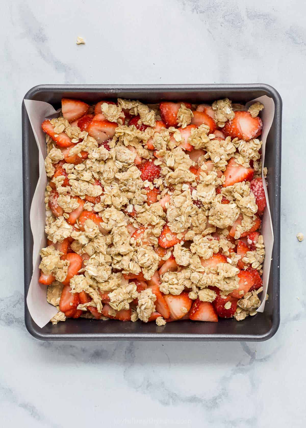 The crumble topping on top of the filling and crust in the prepared baking pan