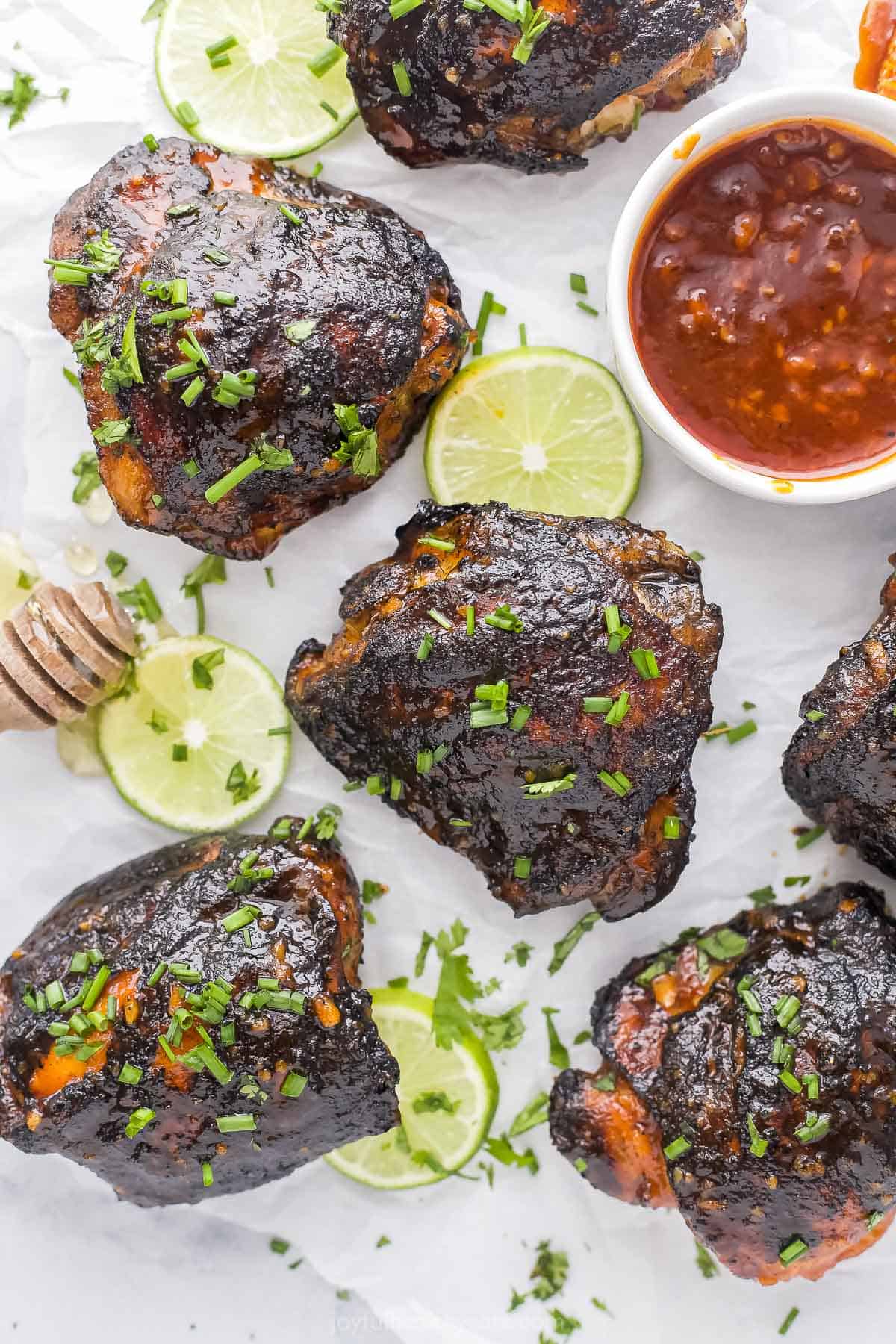 Honey-glazed chicken on a kitchen countertop with fresh limes and honey