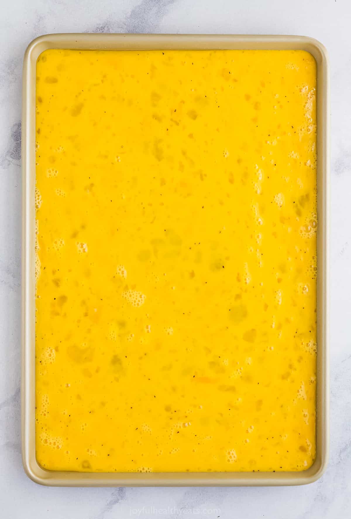 A 15x10-inch baking sheet with the egg mixture poured into it