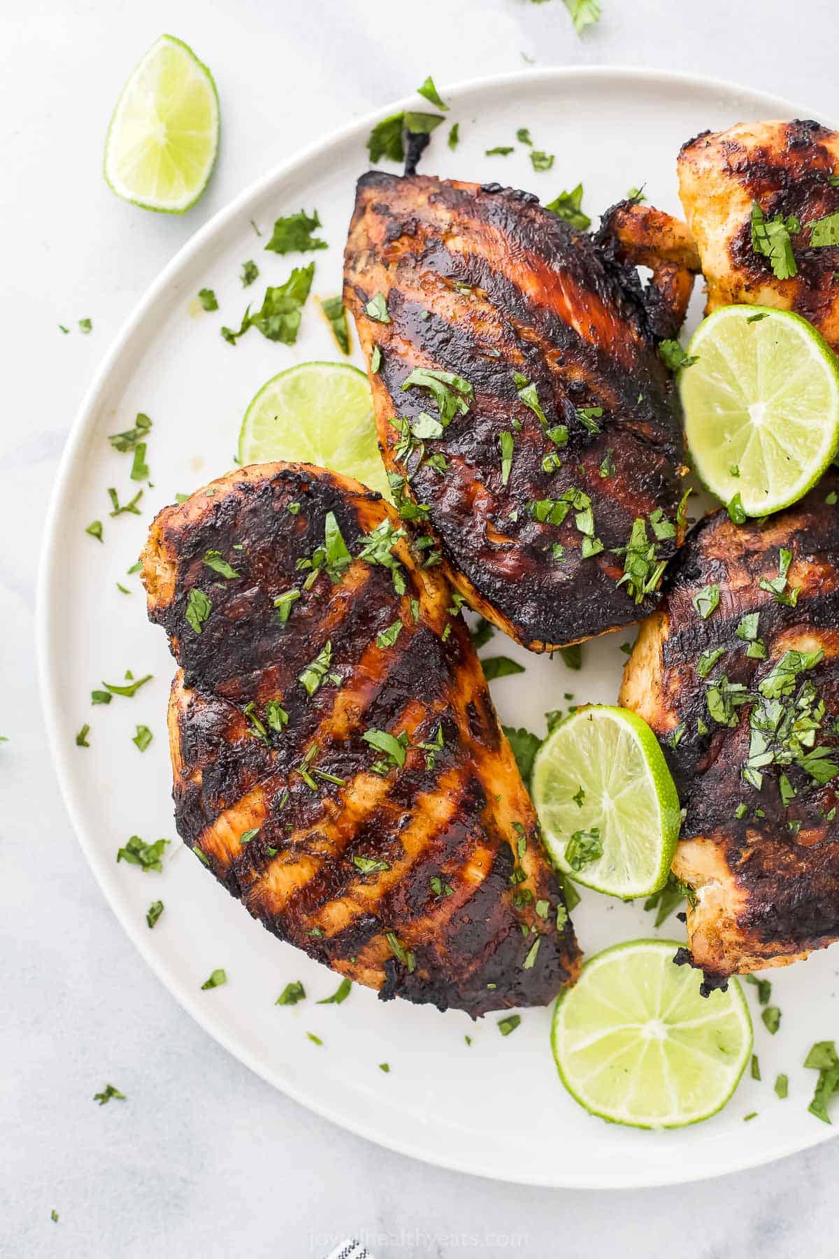 Four tequila lime grilled chicken breasts on a large plate with a rim