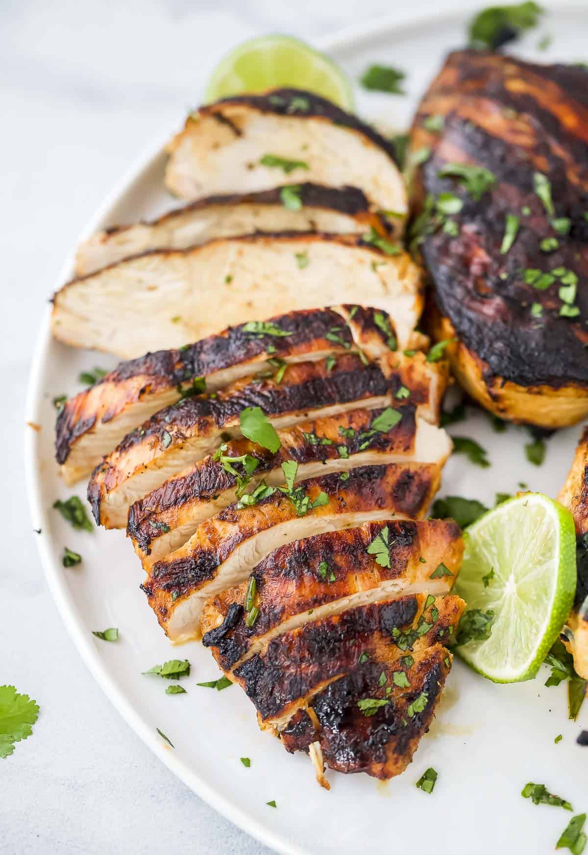 Tequila lime grilled chicken on a plate with chopped parsley sprinkled on top