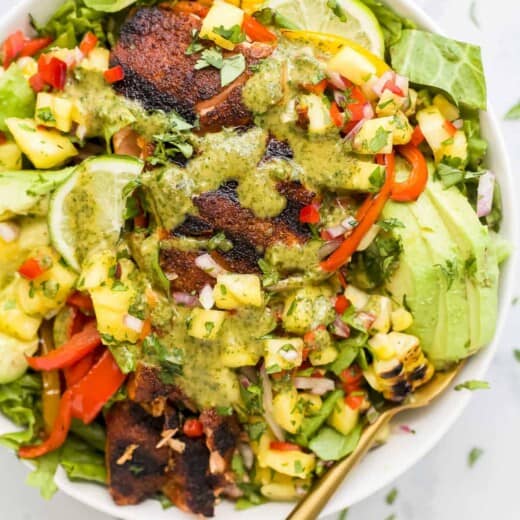 A salmon salad in a large bowl with a golden spoon inside