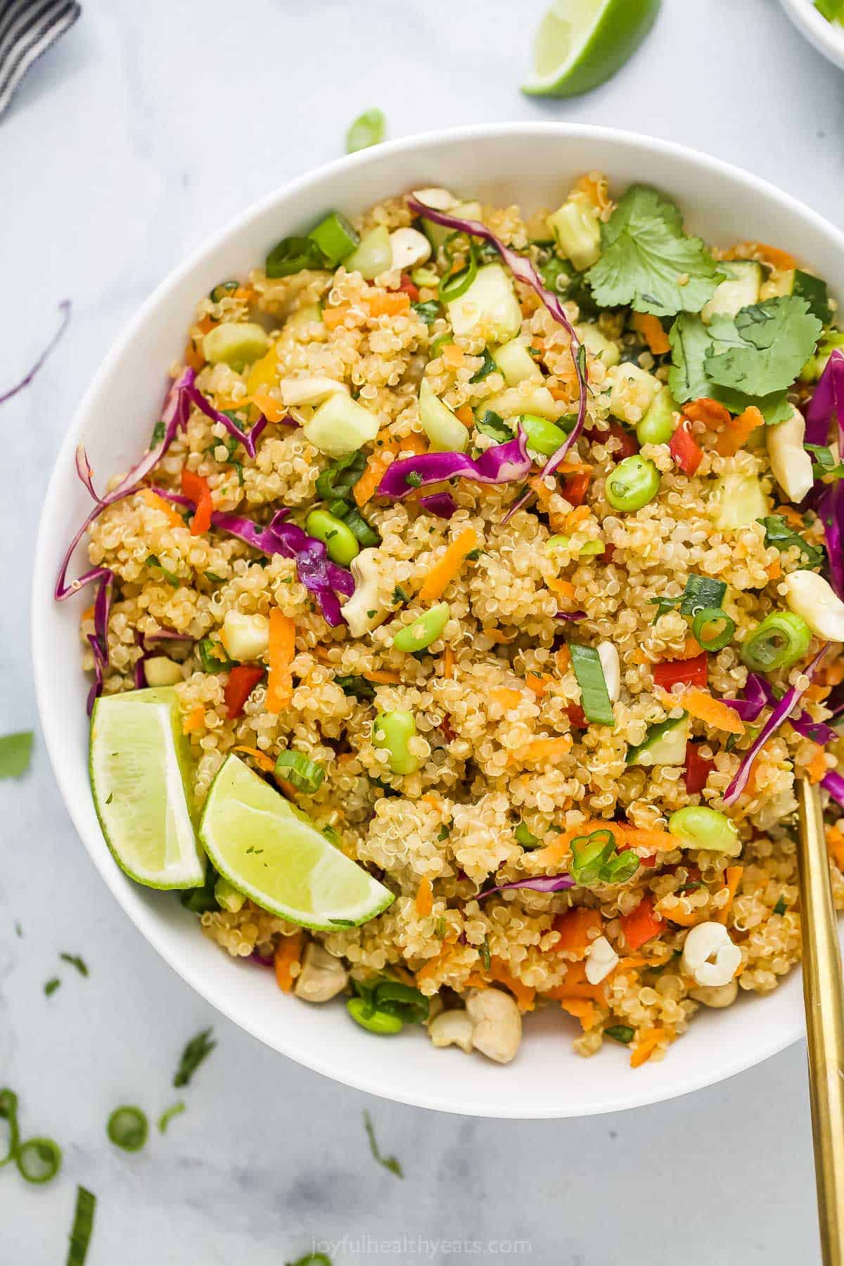 A bowl of quinoa salad on a marble countertop