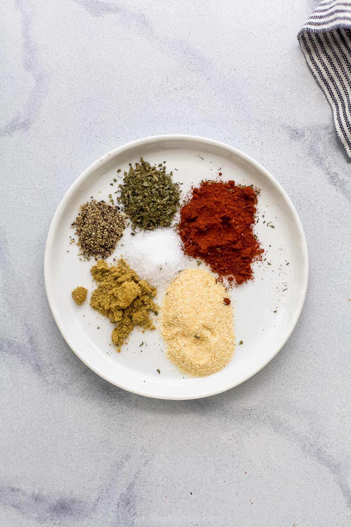 Smoked paprika, dry cilantro and the rest of the spice rub ingredients on a small plate