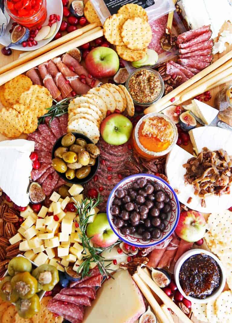 Top view of a holiday charcuterie board with fruits, meats and cheeses.