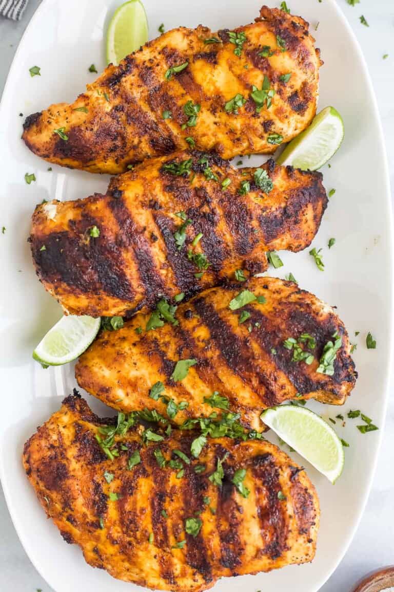 Four garlic lime chicken breasts lined up on a long serving platter
