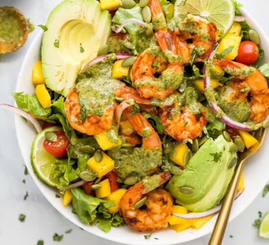A homemade shrimp avocado mango salad with cilantro lime dressing drizzled on top