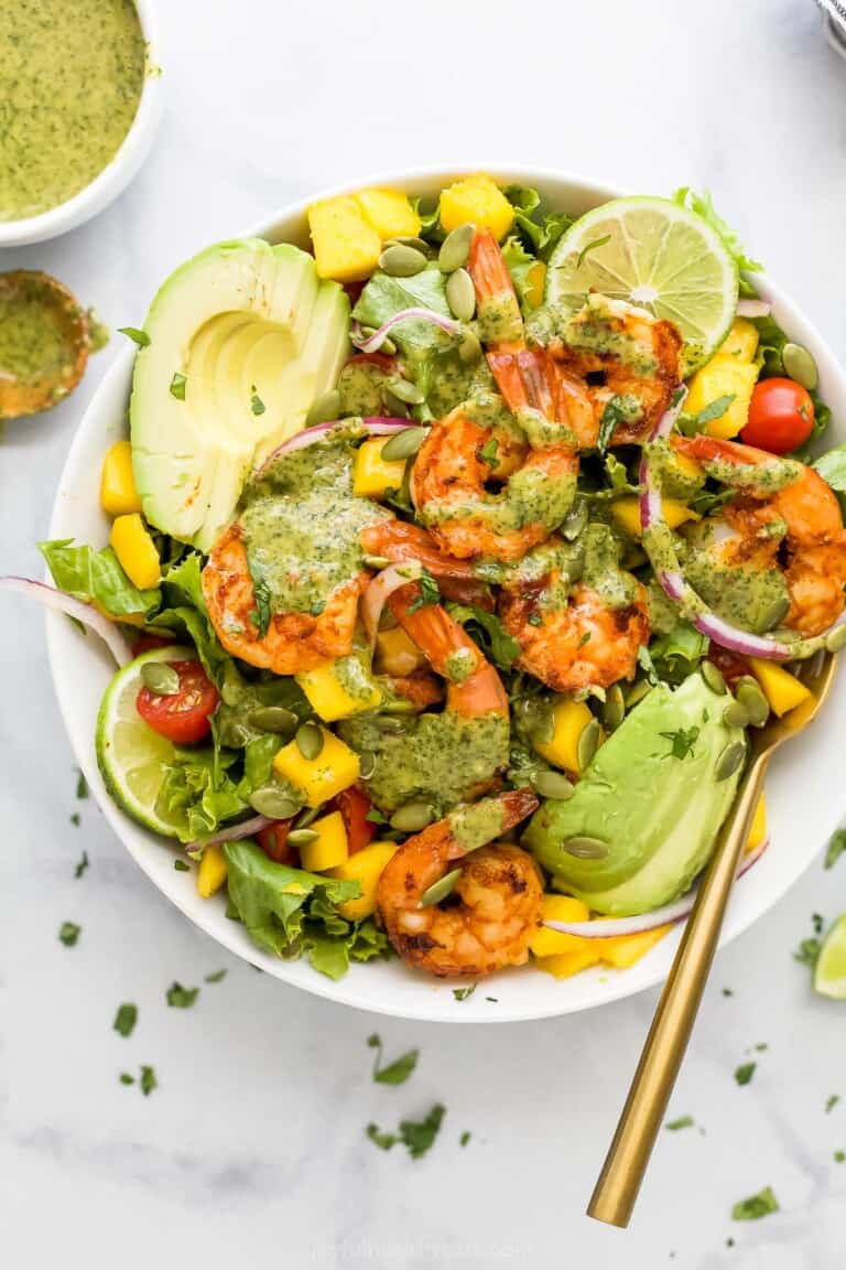 A homemade shrimp avocado mango salad with cilantro lime dressing drizzled on top