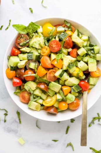 An overhead shot of a bowl of avocado salad with a spoon inside the bowl