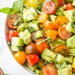 A bowl of avocado tomato cucumber salad on a kitchen countertop