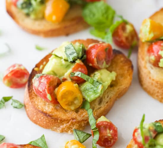 Toasted French bread topped with a tomato, basil and avocado mixture
