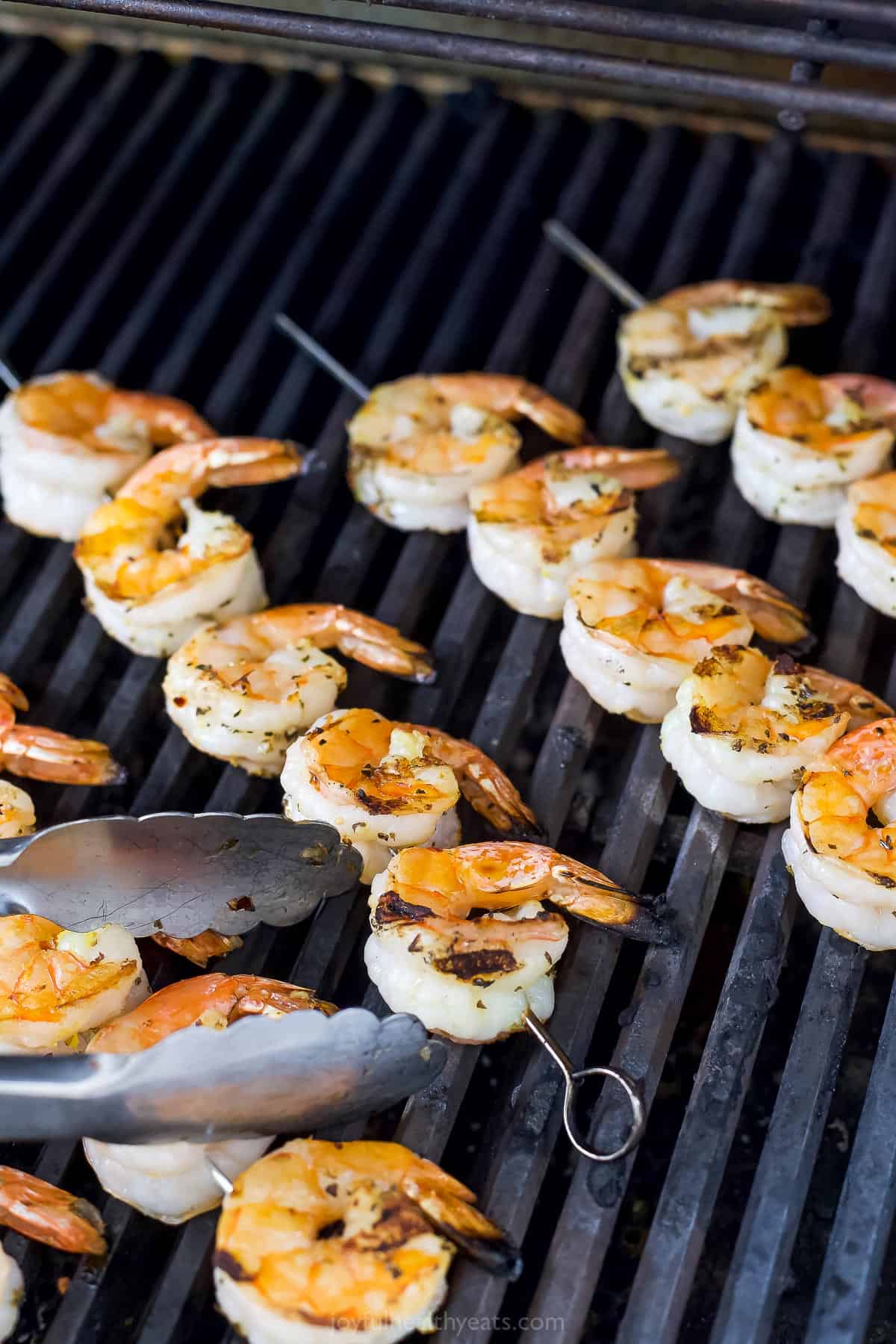 Shrimp cooking on a grill with one side done