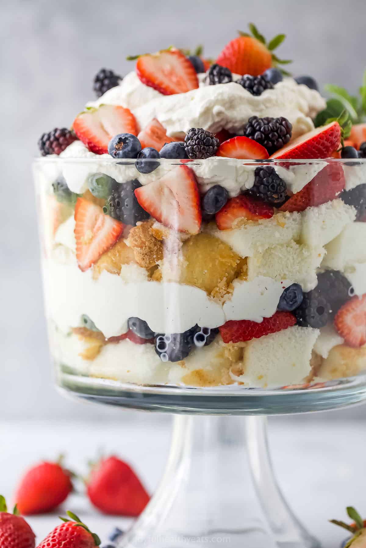 A triple berry whipped cream angel food cake trifle on a kitchen countertop
