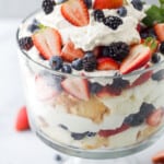 A freshly made strawberry shortcake trifle in a large container on a gray countertop