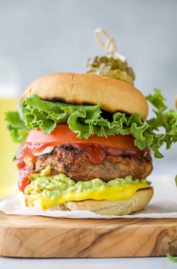 A homemade turkey burger on a cutting board lined with parchment paper