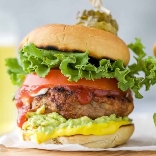 A homemade turkey burger on a cutting board lined with parchment paper