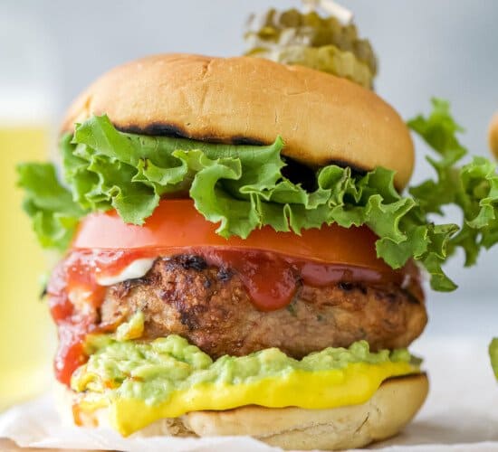 A homemade turkey burger on a cutting board lined with parchment paper