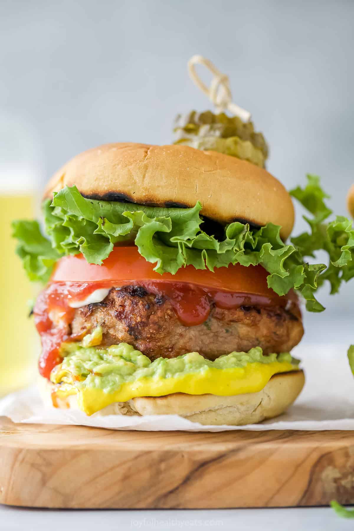 A homemade turkey burger on a cutting board lined with parchment paper