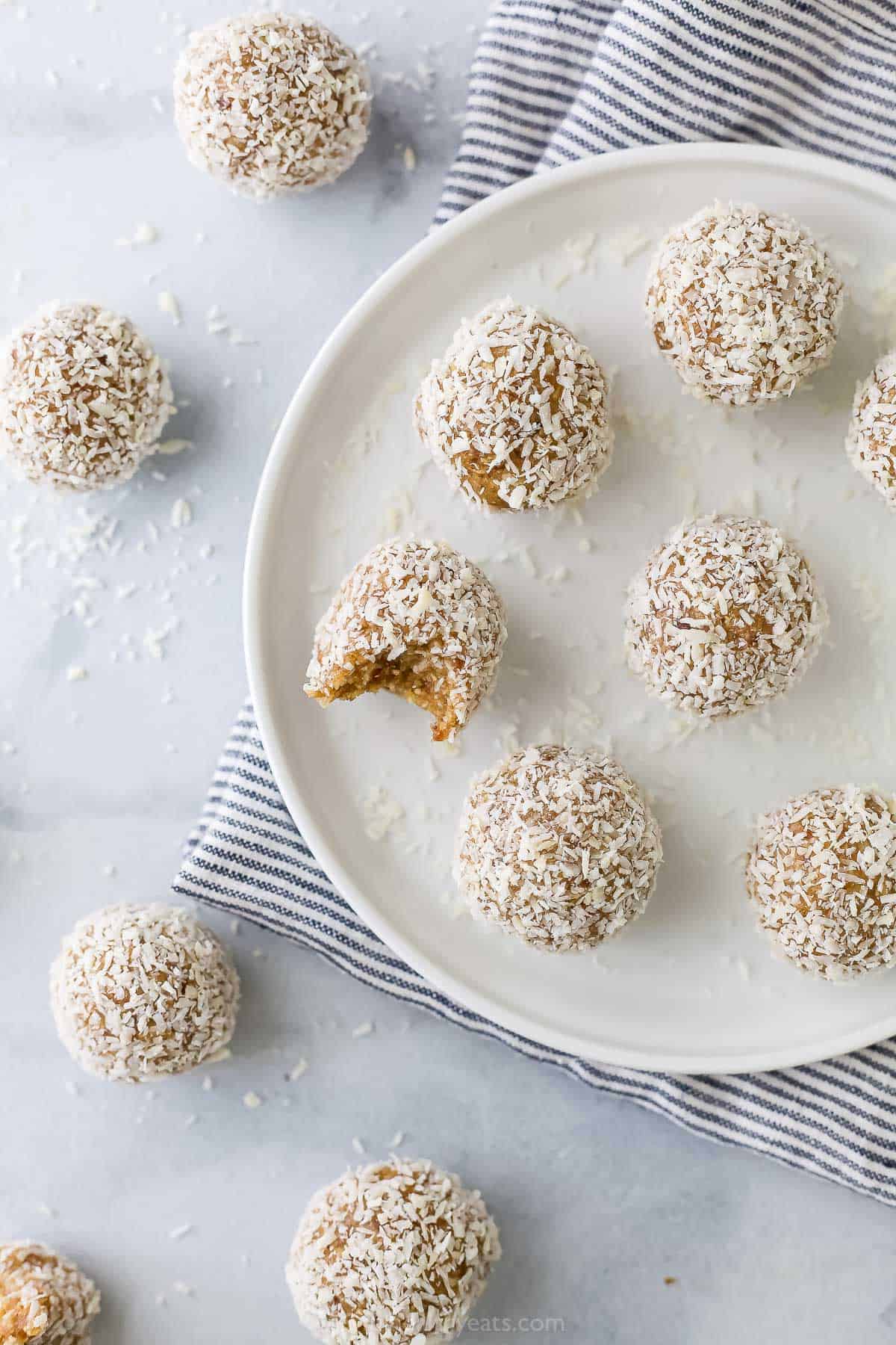 Eight protein bites on a plate with four more on the countertop beside them