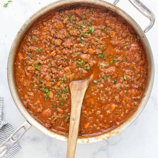 Ragu sauce simmering in pot with beef, vegetables, and tomato sauce