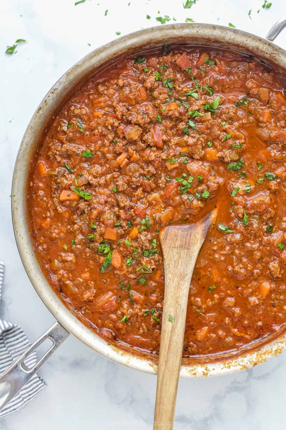 Ragu sauce simmering in pan with beef, vegetables, and tomato sauce