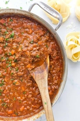 Ragu sauce simmering in pot with beef, vegetables, and tomato sauce