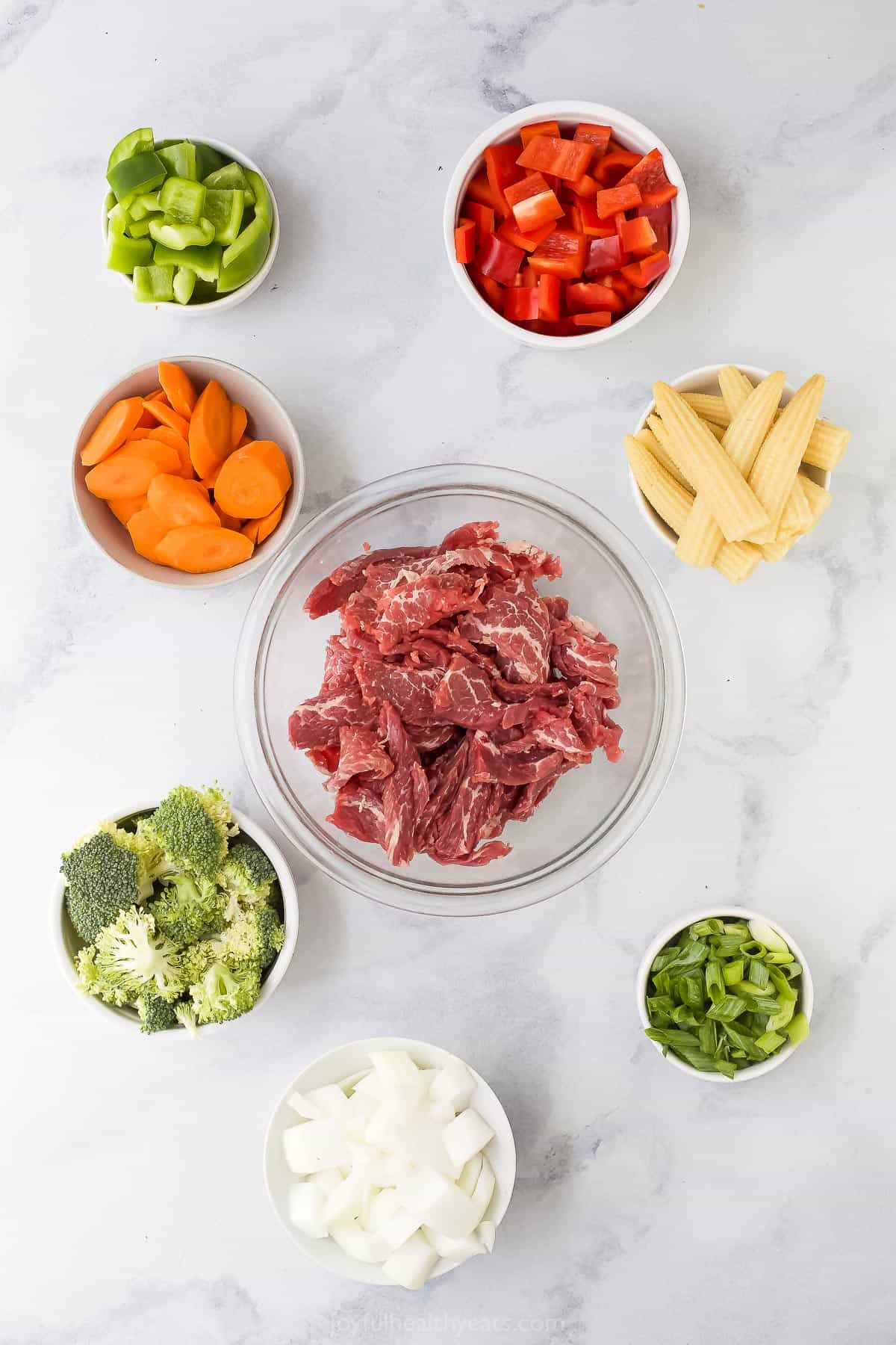 individual prep bowls with ingredients like beef and vegetables to make stir fry