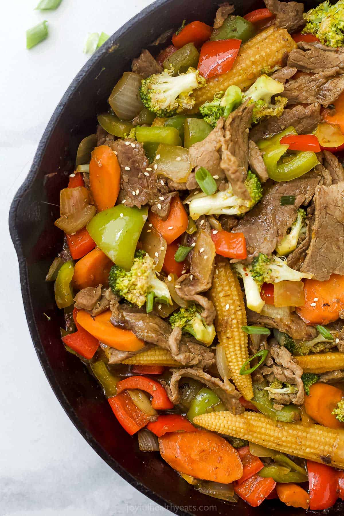 Hunan beef made with vegetables and streak strips in a cast iron skillet