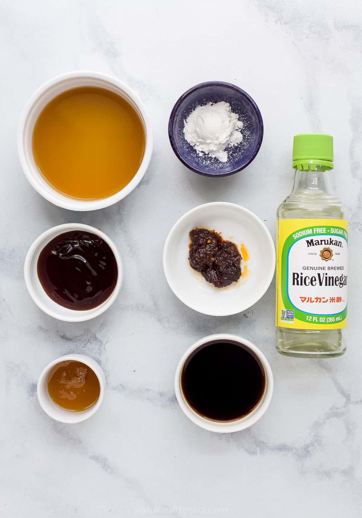 prep bowls with ingredients to make stir fry sauce plus a bottle of rice vinegar