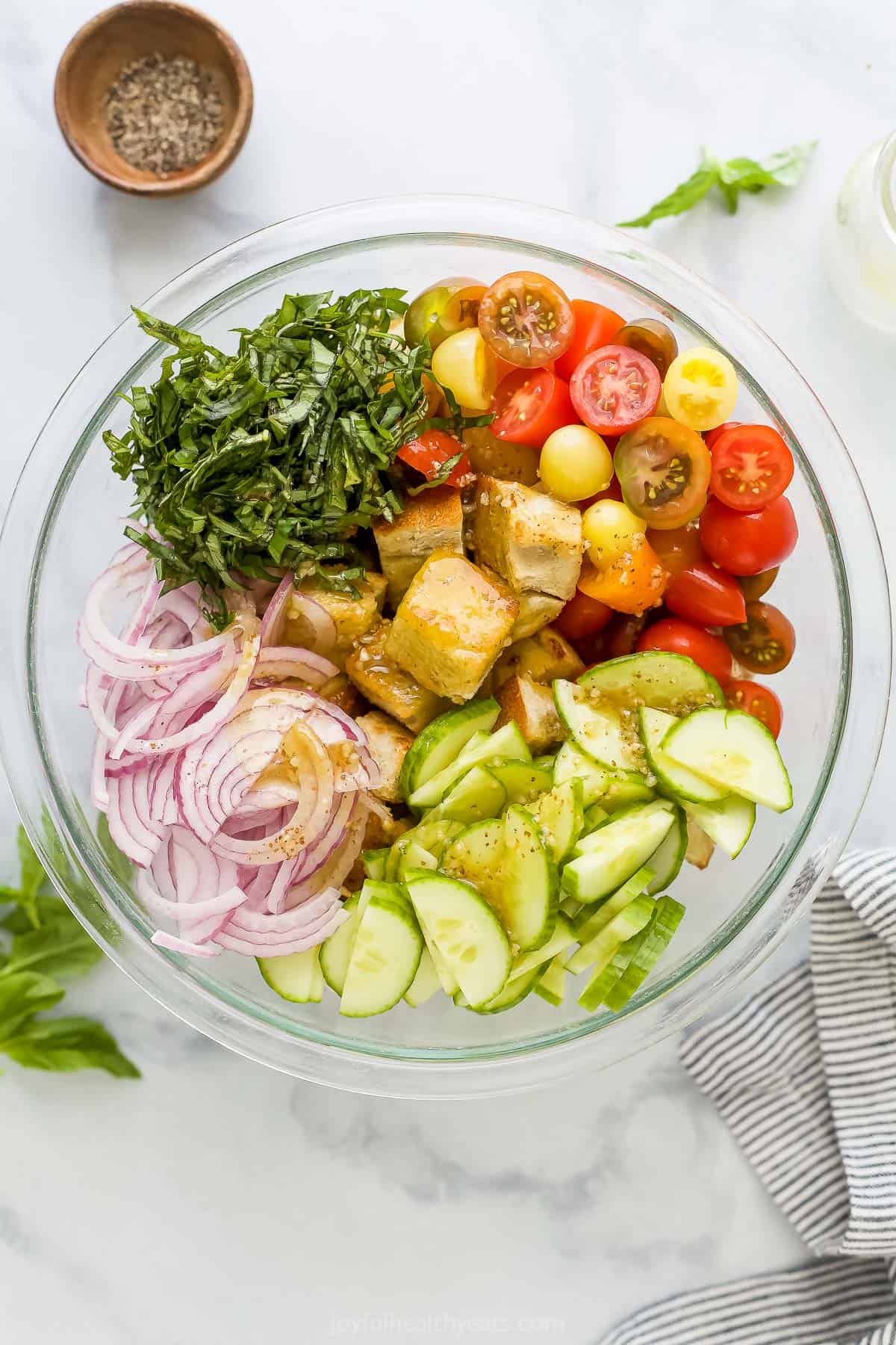 Homemade croutons, fresh basil, sliced cucumbers and the rest of the ingredients in a big mixing bowl