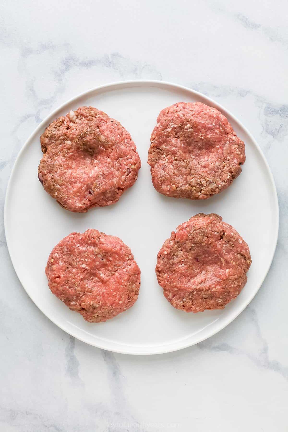 four beef hamburger patties