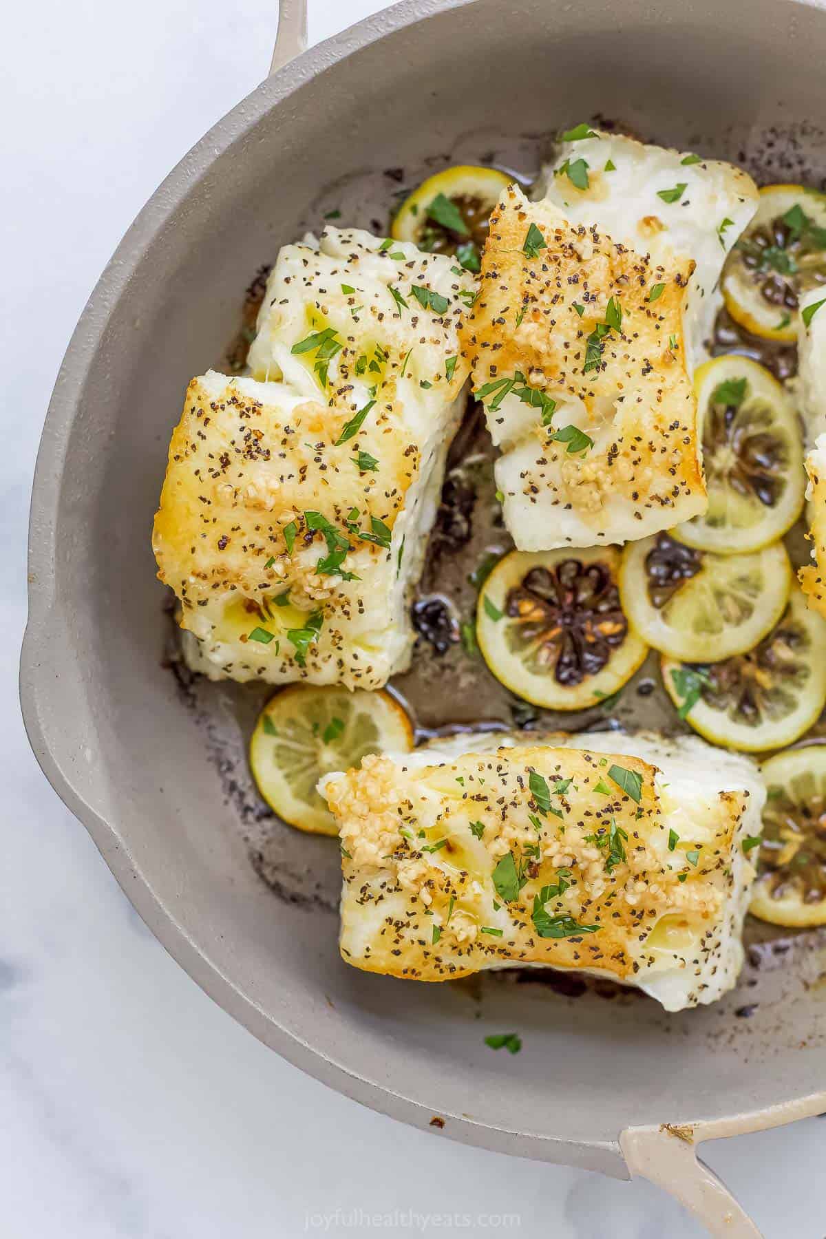 seasoned sea bass in a pan with lemon and ghee