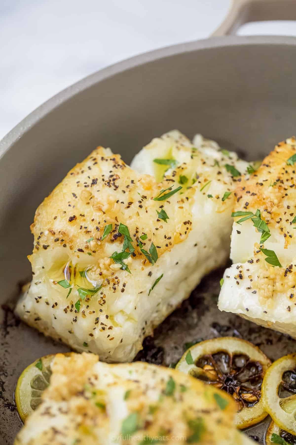 seasoned sea bass in a pan with lemon and ghee