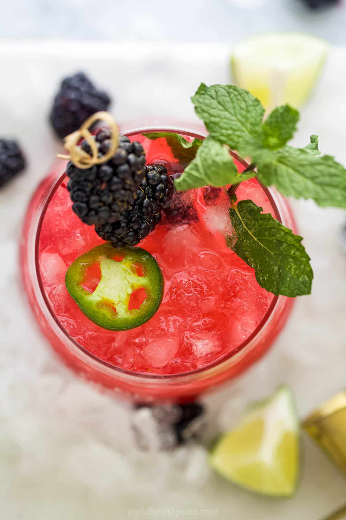 The bird's-eye view of a jalapeño marg garnished with fresh berries, a mint leaf and a jalapeño slice