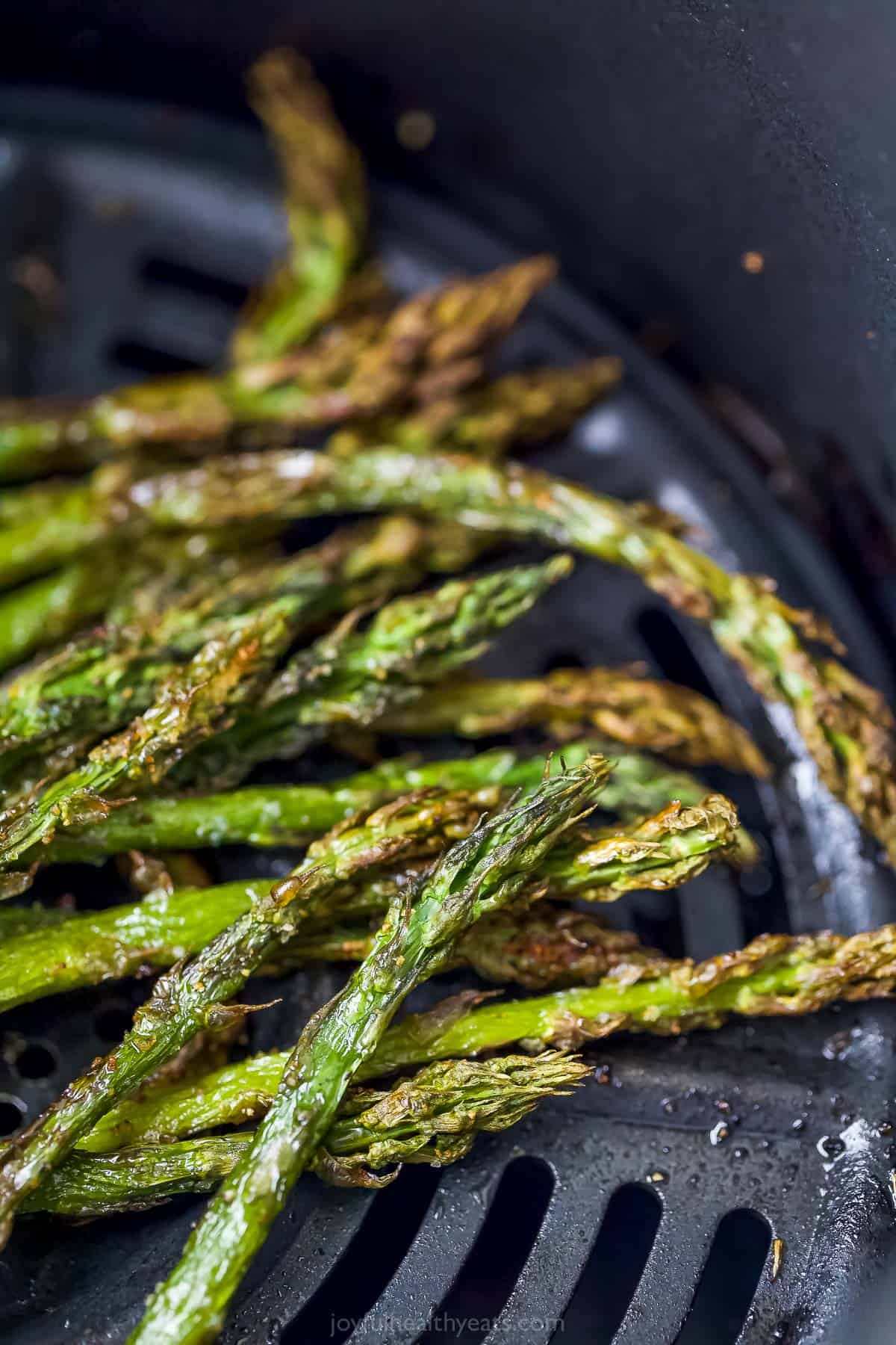 Roasted asparagus stalks in the basket of an Air Fryer
