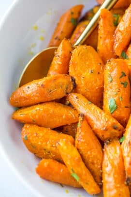 close up of roasted and seasoned carrots in a white bowl