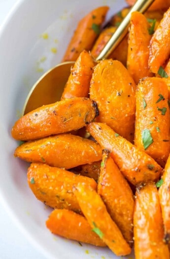 close up of roasted and seasoned carrots in a white bowl