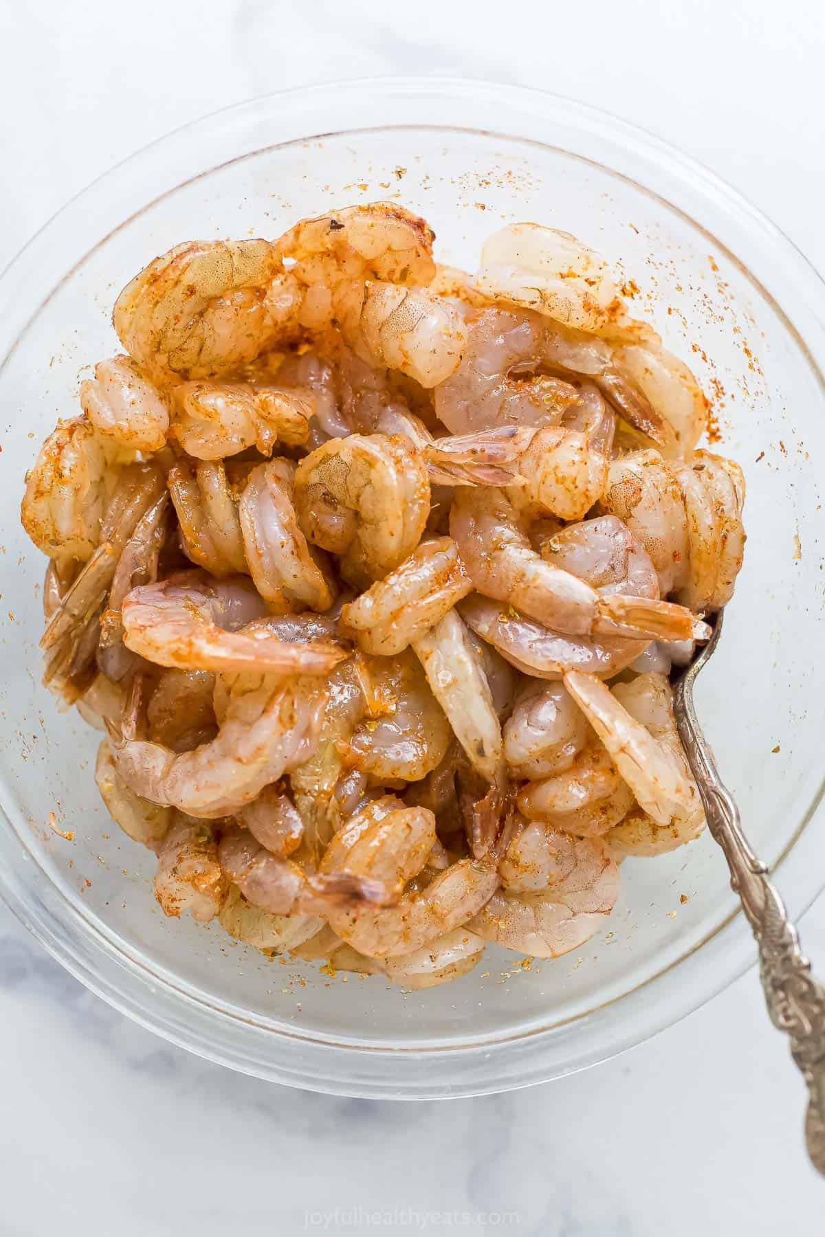 bowl of raw shrimp tossed in seasoning
