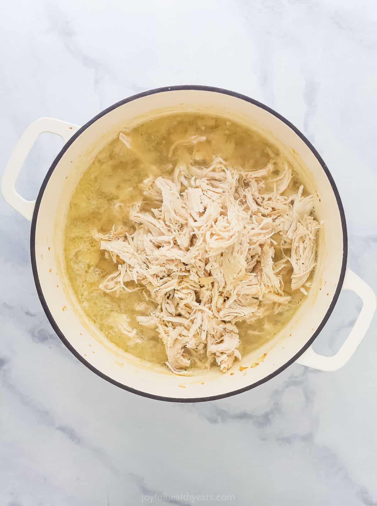 pulled chicken in broth in a large pot