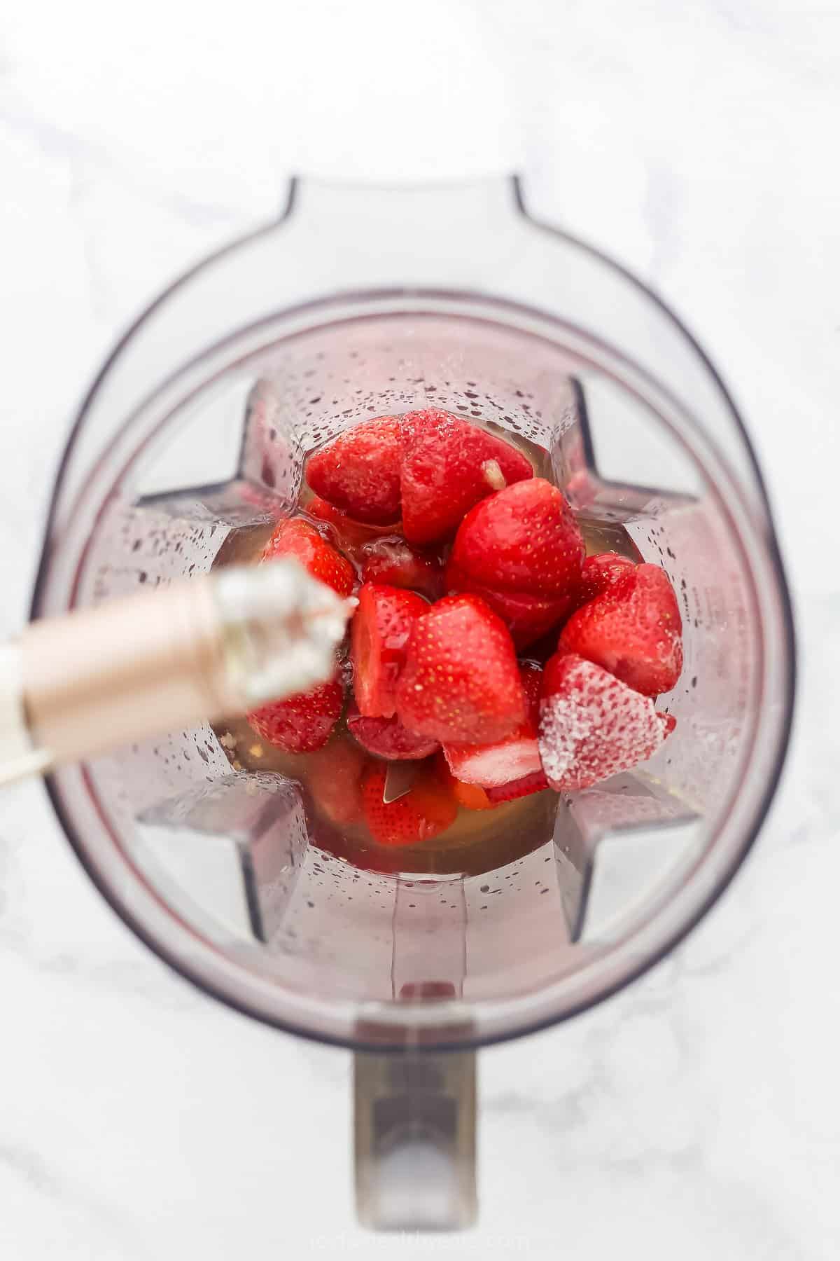 Frozen strawberries in a blender with wine