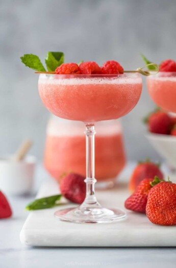 frozen rosé wine in a glass with raspberry garnish