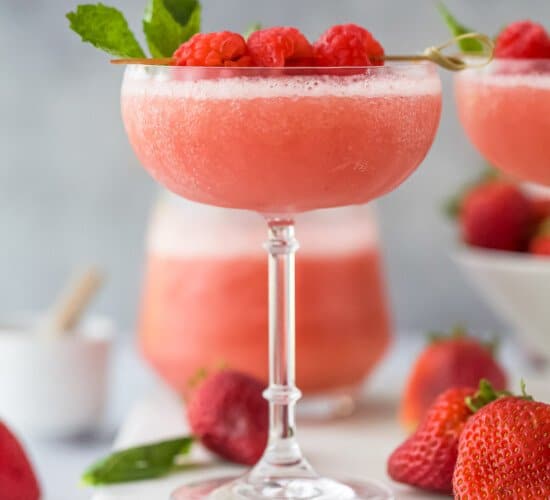 frozen rosé wine in a glass with raspberry garnish