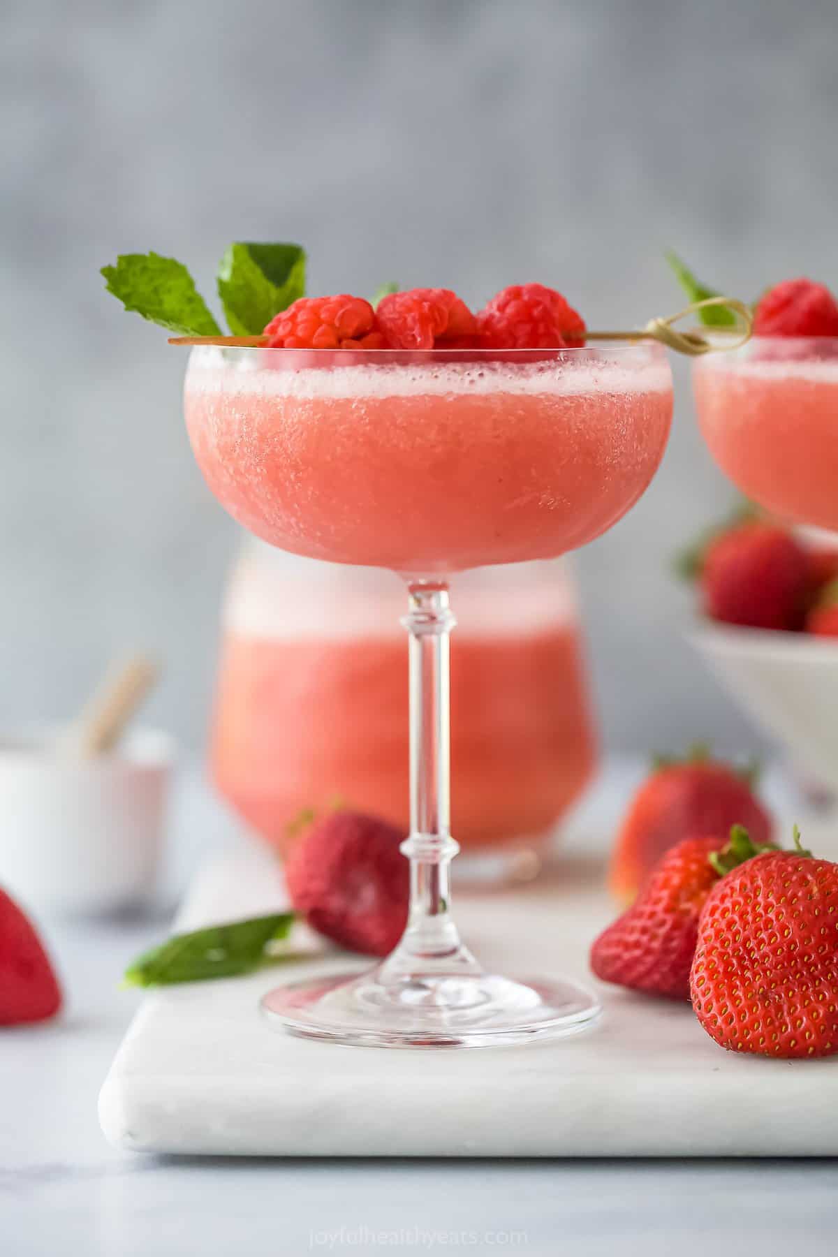 Frozen rosé in a glass with raspberry and mint garnish 