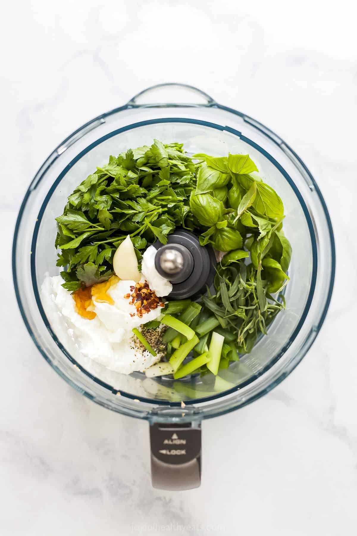 All of the dressing ingredients inside of a blender on a kitchen countertop